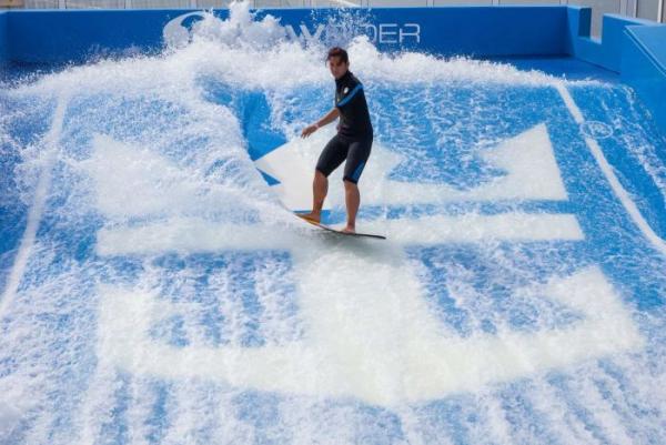 A man surfing on a simulated wave on a cruise ship.